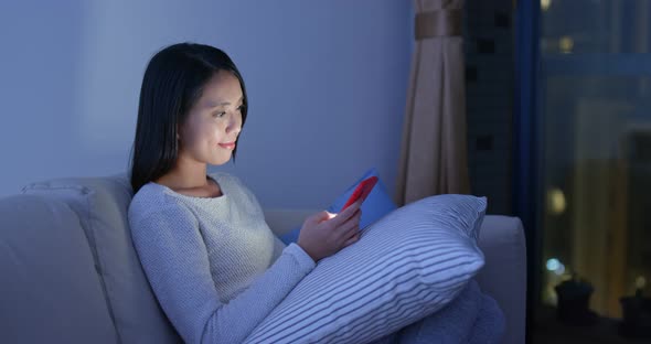 Woman use of cellphone at home in the evening