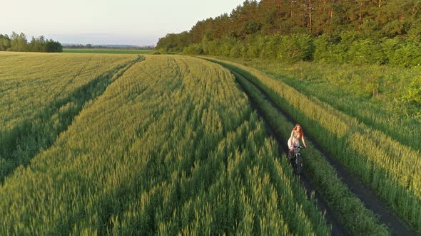 Cute Young Girl on Bicycle in Green Field