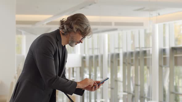 Businessman Using Smartphone At Railing