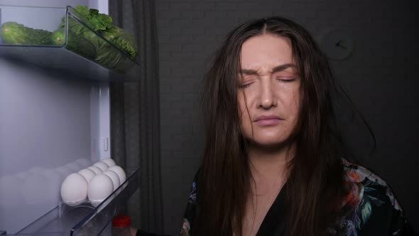 Sleepy Hungry Woman Takes Chocolate Cake From Fridge Shelf