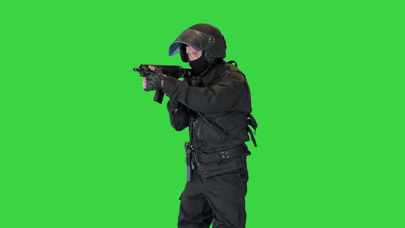 Spec Ops Soldier in Black Uniform Aiming with Rifle on a Green Screen Chroma Key