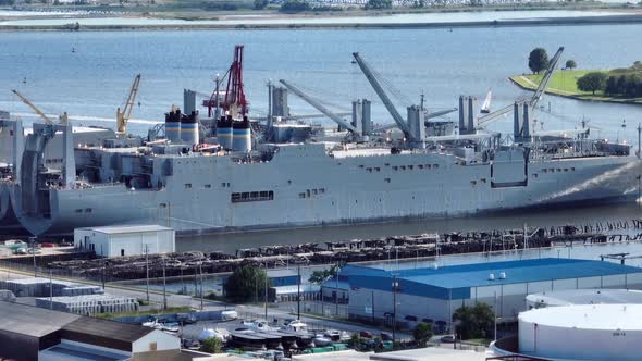 Large cargo freighter ship at dock in port. Bulk fuel tank storage in American port city. Aerial vie