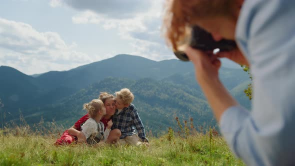 Man Photographing Woman Kids in Front Mountains