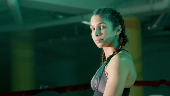 Young Female Athlete Posing at Camera While Training in Gym