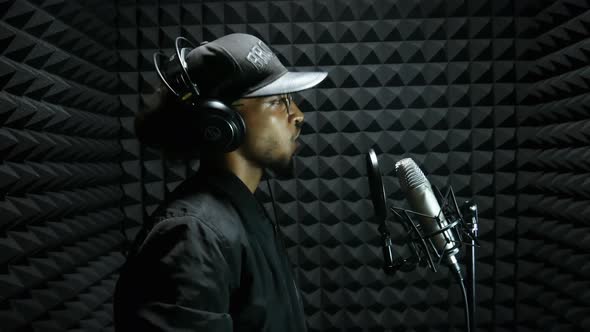 Mixed Race Male Rap Singer Recording a Vocal and Singing His Song in the Microphone in the Sound