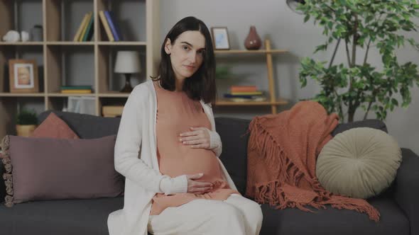 Pregnant Woman Caressing Her Belly at Camera at Home