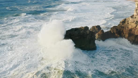 Massive Foamy Waves Crashing Onto a Rocky Coast As Seen From Above