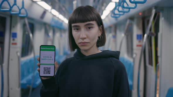 Woman Holding Smartphone with Covid Passport on Screen