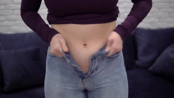 Overweight Woman Measuring Waist with Too Small Jeans Pulling Up Tight Jeans