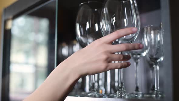 A large wine glass goes to the girl from the closet. Close-up of a hand