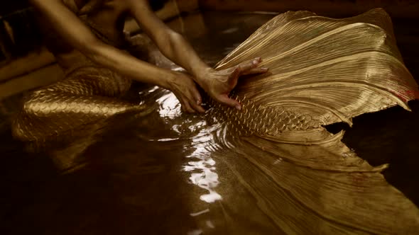 Closeup of Female Hands in Gold Touching a Silicone Tail Like a Mermaid in a Fairy Tale