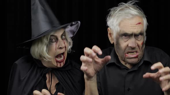 Elderly Man and Woman in Halloween Costumes. Witch and Zombie