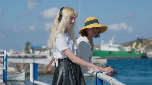 Mother and Teenage Daughter Standing Together on Sea City Embankment Talking