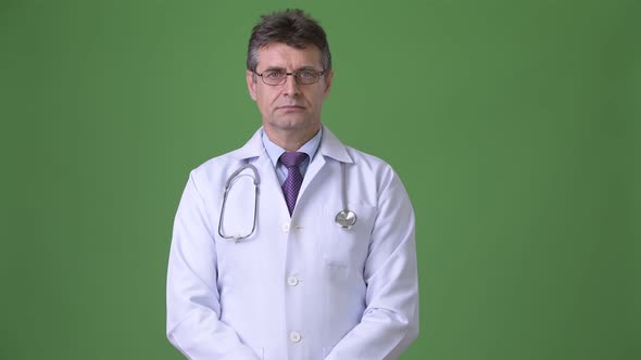 Mature Handsome Man Doctor Against Green Background