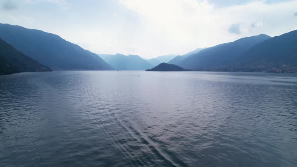 Lake Como, Italy, Europe. Drone over water, aerial ascend backwards. Travel background.