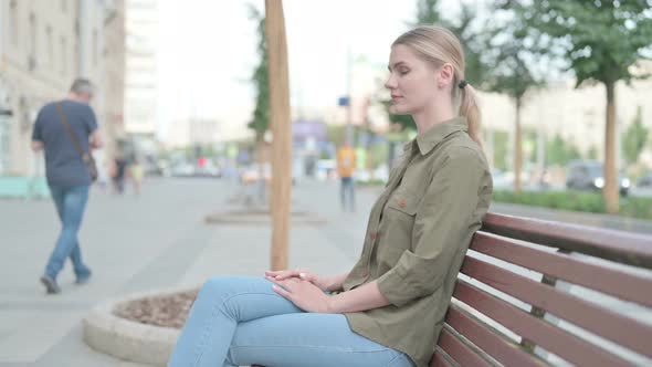 Woman Looking at Camera while Sitting on Bench