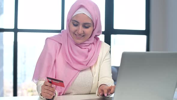Muslim Woman Wearing Hijab Using Laptop for Online Shopping at Office