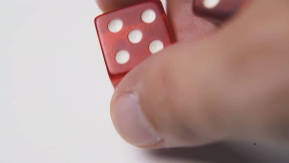 Man Shows and Throws Red Dices on Light Background Macro