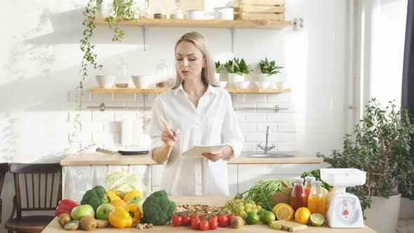 Nutritionistblogger Talks About Healthy Eating While Standing at a Table with Lots of Vegan Food