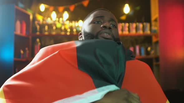 Afro-American Fan Waving Flag of Germany in Pub, Upset About Sports Team Defeat