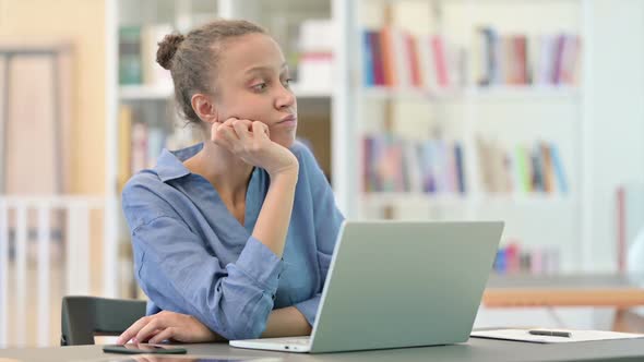 Pensive African Woman Sitting and Thinking in Library