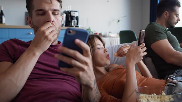 Group of friends using mobile phones at the home party. Shot with RED helium camera in 8K