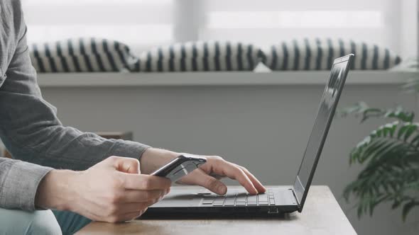 Man Using Smartphone and Laptop Connected to Work and Searching Information at Office