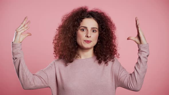 Cute Woman Showing Bla-bla Gesture with Hands and Rolling Eyes Isolated on Pink