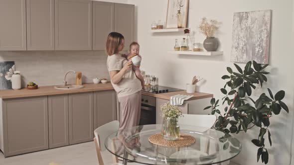 Woman with Infant Drinking Coffee