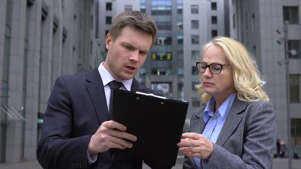 Male Company Worker Discussing Contract Details With Mature Female Colleague