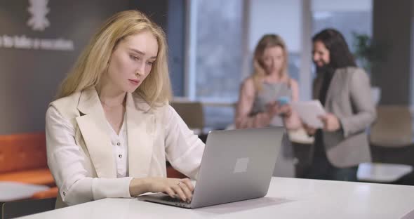 Portrait of Young Serious Caucasian Woman Typing on Laptop Keyboard. Portrait of Confident