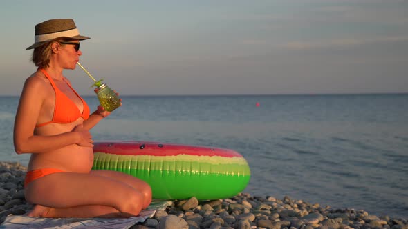 Pregnant Woman Relaxing on a Beach