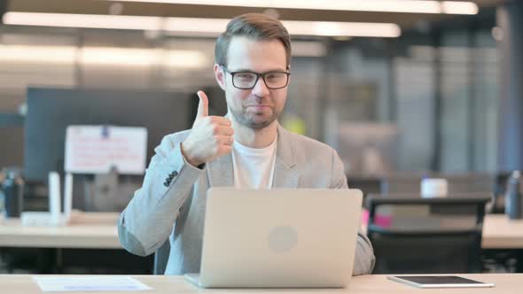 Thumbs Up by Man with Laptop in Office