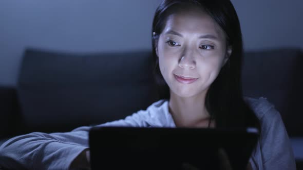 Woman using tablet computer at night 