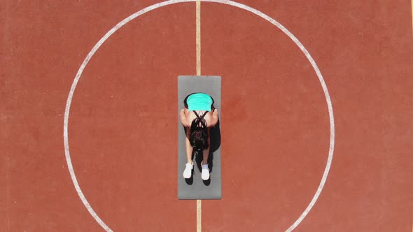 Aero, Top View, Fitness Woman in Sportswear Doing Various Exercises. Background of Orange Basketball