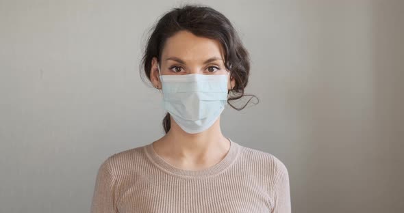 Young Woman Shows How To Wear Protective Medical Mask. Beautiful Girl Shows Protective Mask During