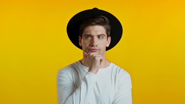 Thinking Hipster Man Looking Up and Around on Yellow Background. Worried Contemplative Face