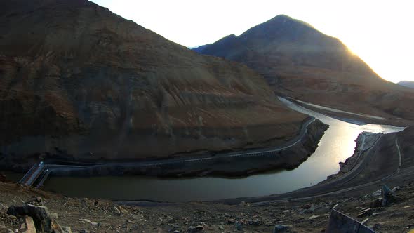 the confluence and convergence of river zanskar and indus with mountains and sun in the background