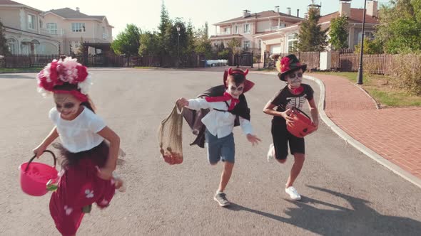 Excited Kids in Halloween Costumes Running down Street