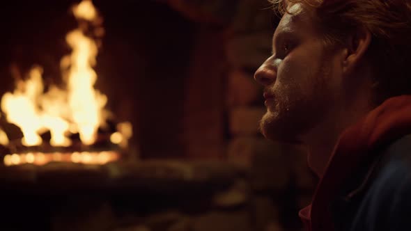 Thoughtful Man Sit Fireplace in Vacation House