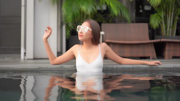 Young asian woman enjoy around outdoor swimming pool for leisure