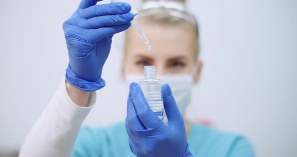 Female Scientist Using Pipette Analyzes a Liquid