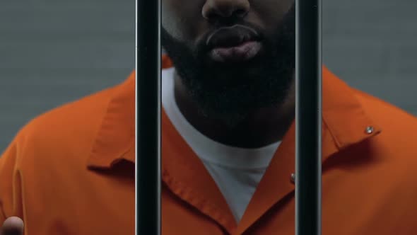 Dangerous African-American Criminal Holding Prison Bars, Imprisonment, Close-Up