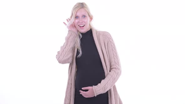 Happy Young Blonde Pregnant Woman Thinking and Listening