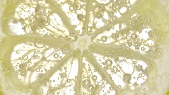 Water with Lemon Slices and Exploding Soda Air Bubbles