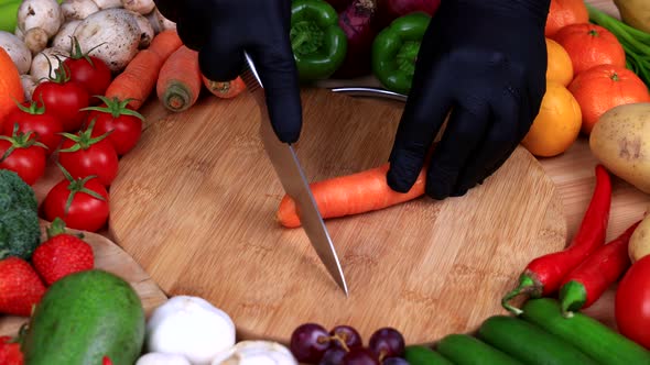 Chef using a knife cutting fresh carrot