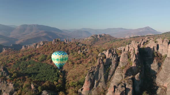 Hot air balloon over picturesque rock formation