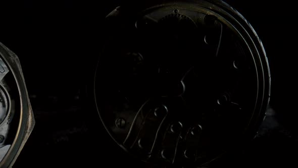 Two Antique Pocket Watches with a Working Clockwork in Darkness and in Light on Black Background