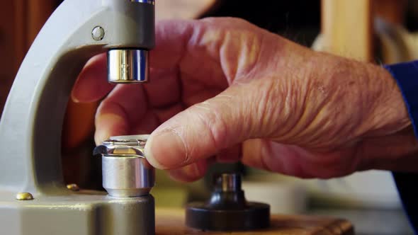 Horologist repairing a watch on a machine