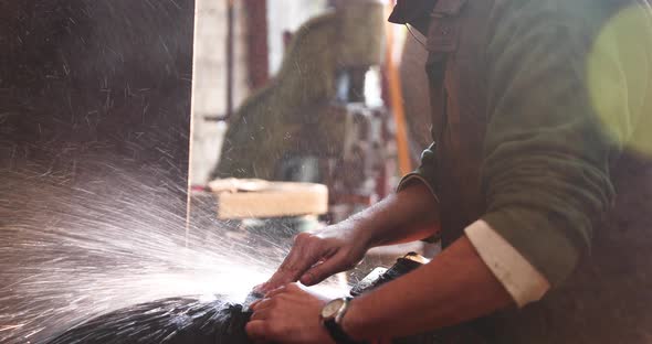 Bladesmith wet grinding a blade